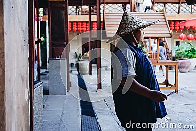 Lhong 1919, a staff with traditional chinese hat Editorial Stock Photo